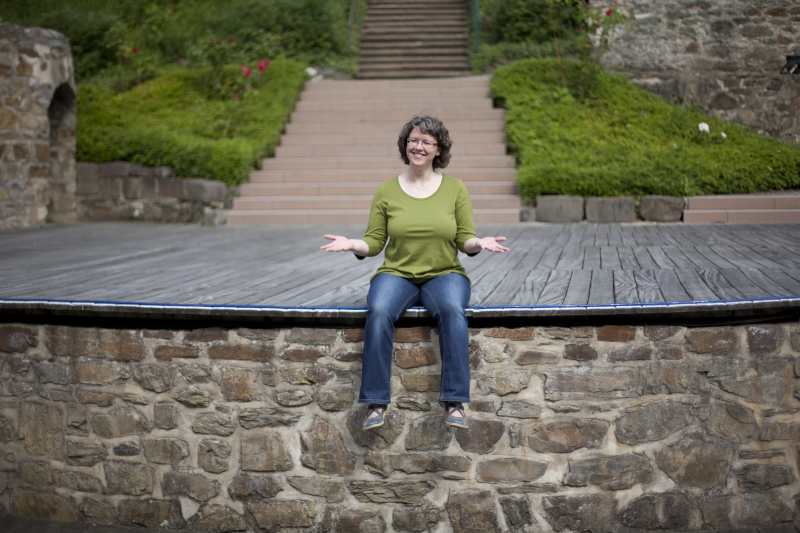 Daniela Wilhelm sitzt mit ausgebreiteten Armen auf einer Freilichtbühne in Wetzlar.
